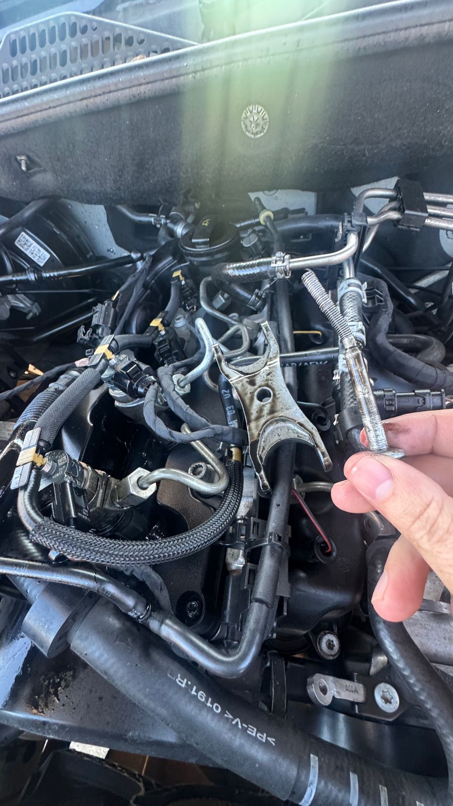 Bent injector clamp bolt held in hand